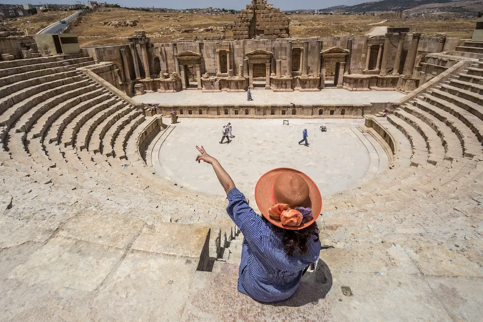 woman pointing in Jordan ancient ruins hosted by Ghardy Tours